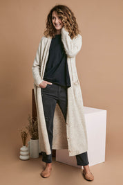 Model Emma wearing size OneSize of the Kinsella Cardigan in colour Tusk, from the front, showing the whole outfit
