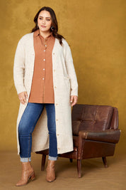 A model wearing the Kinsella Cardigan in colour Tusk, from the front, showing the whole outfit