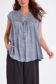 Model Madeline wearing size S of the Elan Top in colour Denim (Blue), from the front, cropped image