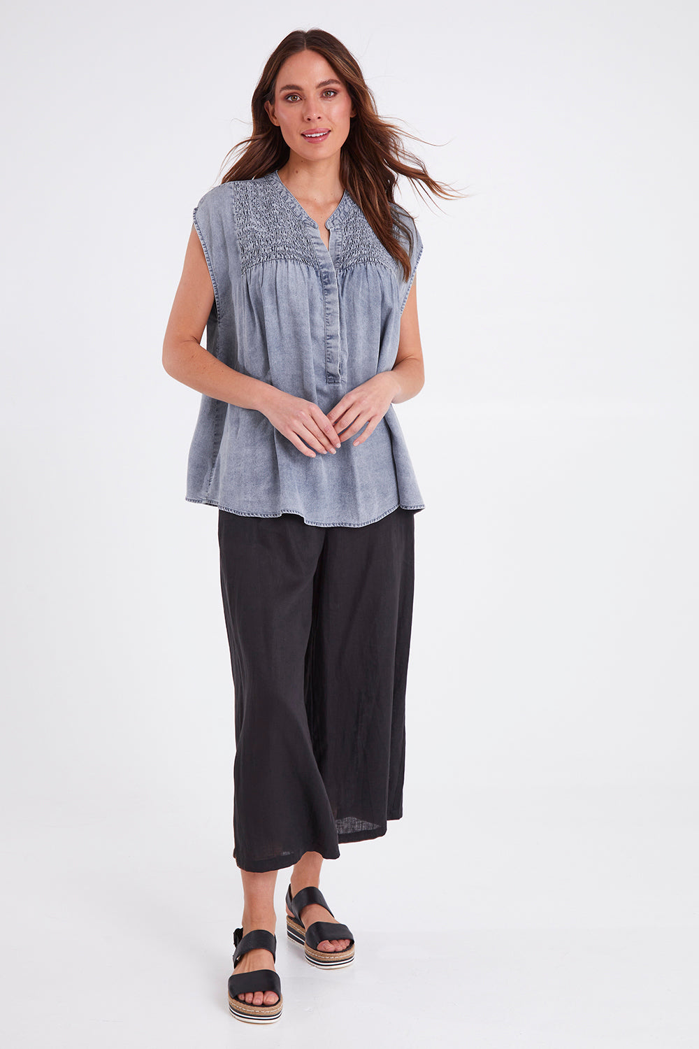 Model Madeline wearing size S of the Elan Top in colour Denim (Blue), from the front, showing the whole outfit