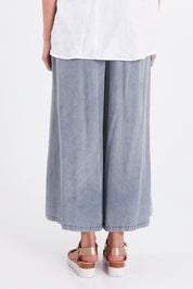 Model Madeline wearing size S of the Elan Pant in colour Denim (Blue), from the back