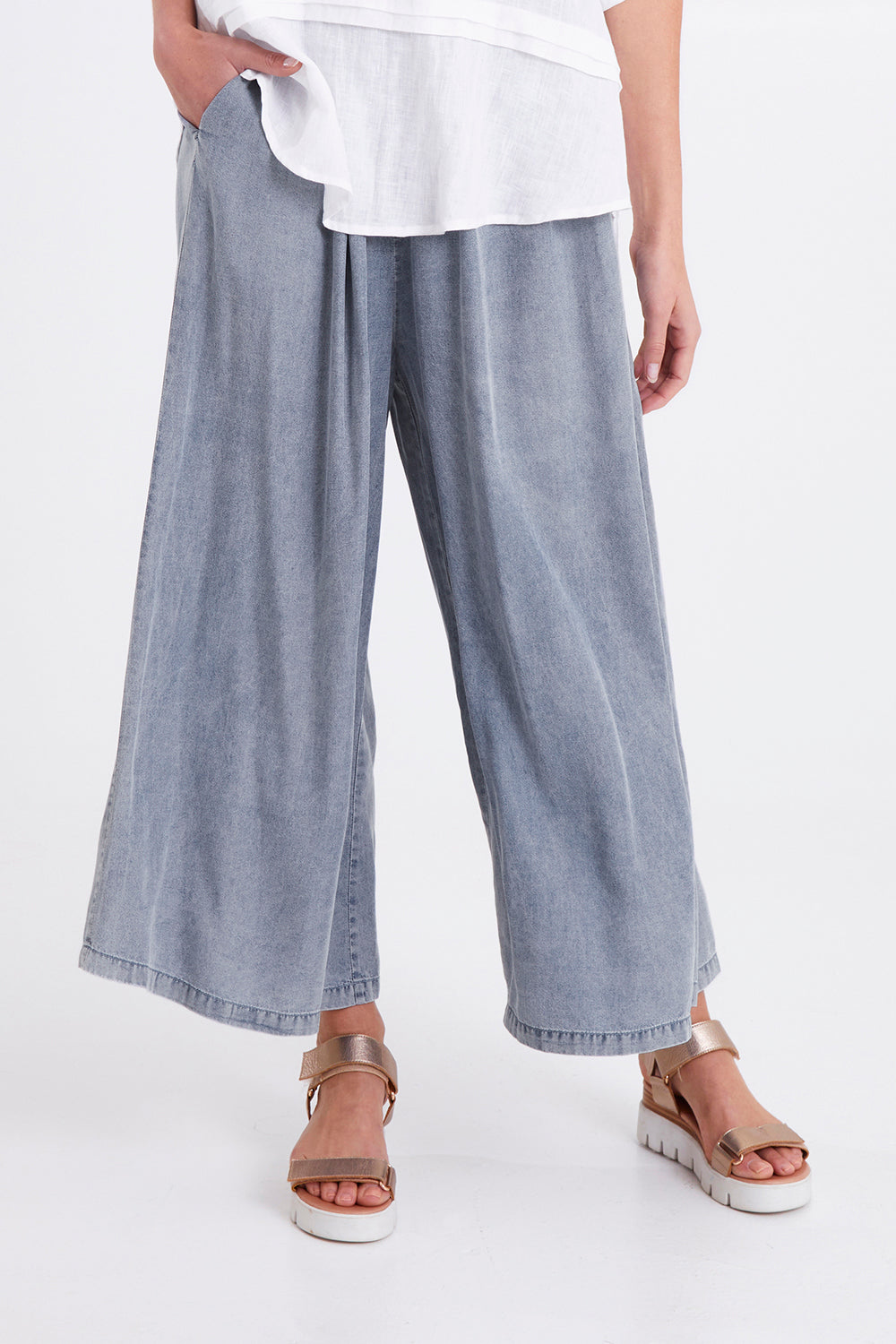 Model Madeline wearing size S of the Elan Pant in colour Denim (Blue), from the front, cropped image