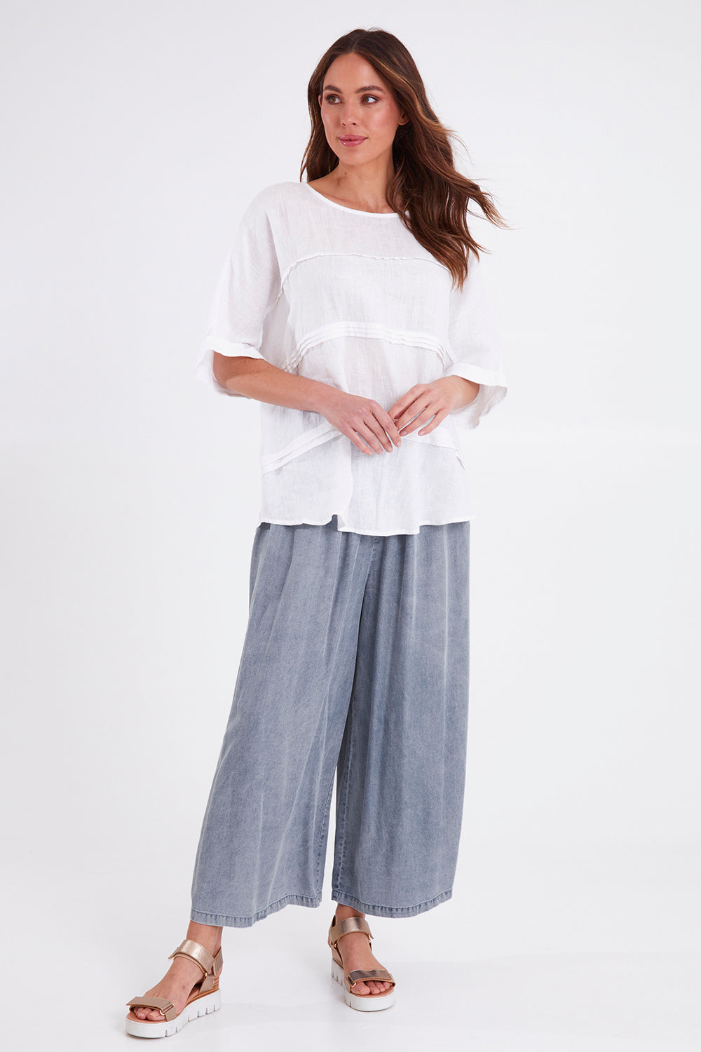 Model Madeline wearing size S of the Elan Pant in colour Denim (Blue), from the front, showing the whole outfit