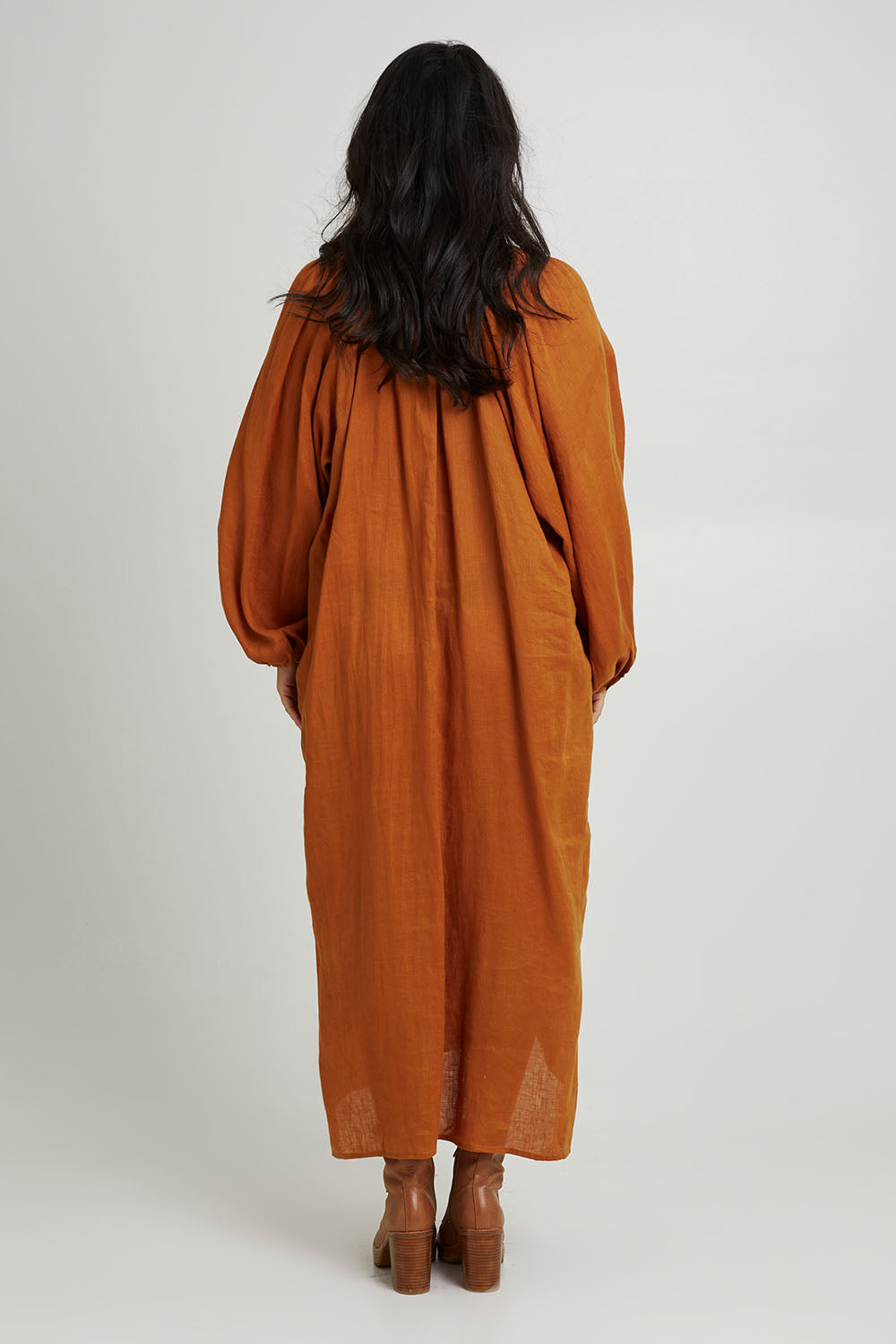 Model Katie wearing size S of the Nama Dress in colour Ochre, from the back