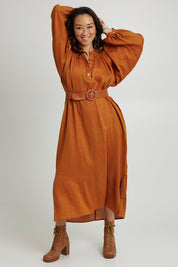 Model Katie wearing size S of the Nama Dress in colour Ochre, from the front, showing the whole outfit