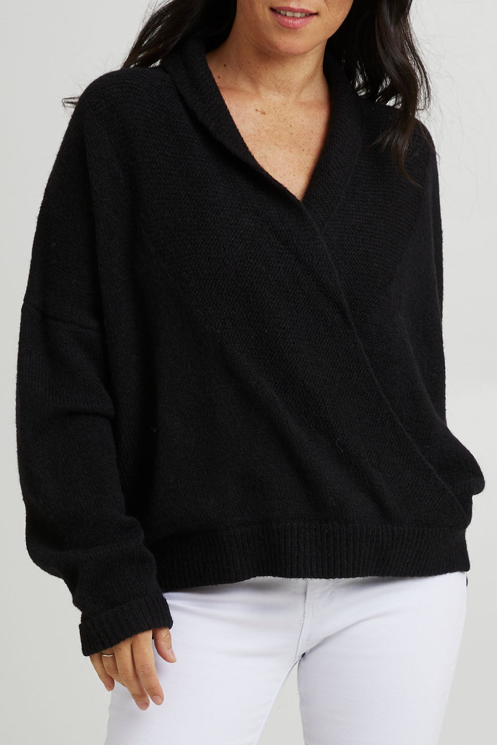 Model Katie wearing size S of the Parrl Crossover Knit in colour Ebony (Black), from the front, cropped image