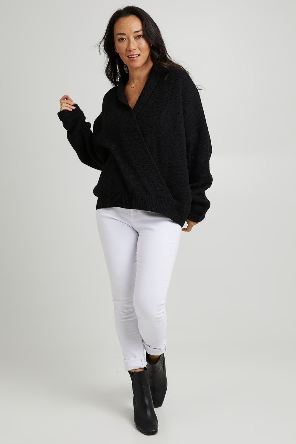 Model Katie wearing size S of the Parrl Crossover Knit in colour Ebony (Black), from the front, showing the whole outfit