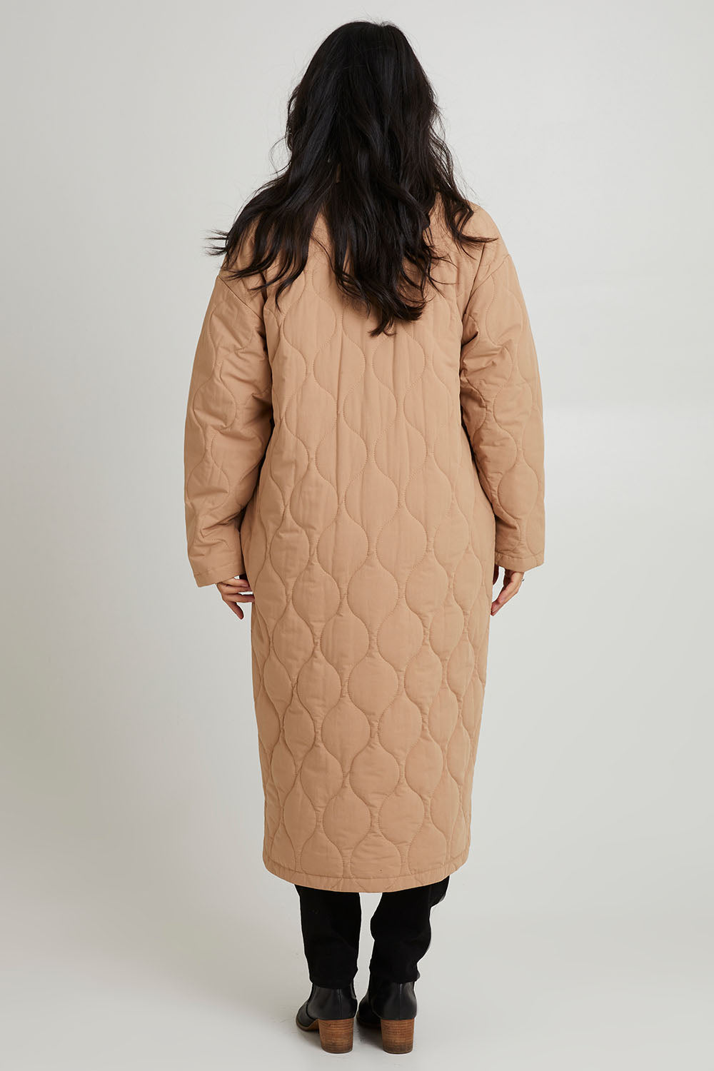 Model Katie wearing size S of the Ribe Coat in colour Putty, from the back