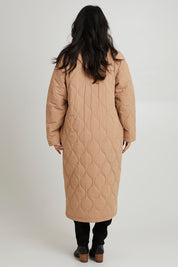 Model Katie wearing size S of the Ribe Coat in colour Putty, from the back