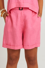 Model Olivia wearing size S of the Halcyon Linen Shorts in colour Musk (Pink), from the front, cropped image
