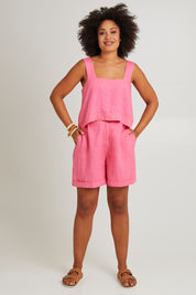 Model Olivia wearing size S of the Halcyon Linen Shorts in colour Musk (Pink), from the front, showing the whole outfit
