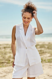Model Lala wearing size S of the Halcyon Linen Shorts in colour Opal (White), from the front, showing the whole outfit