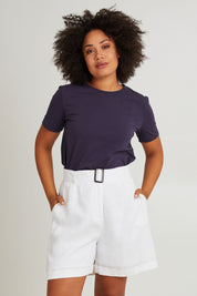 Model Olivia wearing size S of the Halcyon Linen Shorts in colour Opal (White), from the front, cropped image