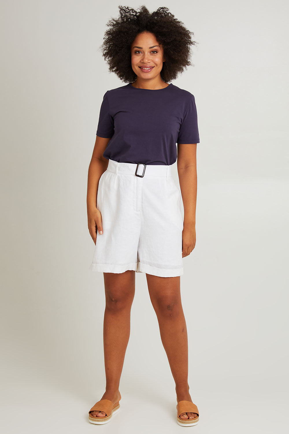 Model Olivia wearing size S of the Halcyon Linen Shorts in colour Opal (White), from the front, showing the whole outfit