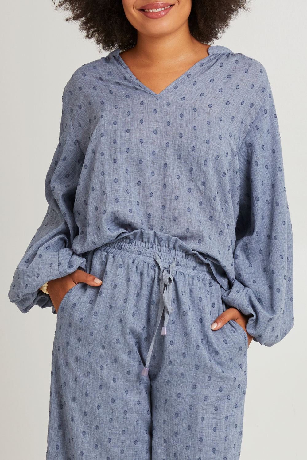 Model Olivia wearing size S of the Zephyr Blouse in colour Nevada (Blue), from the front, cropped image