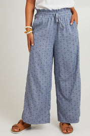 Model Olivia wearing size S of the Zephyr Pant in colour Nevada (Blue), from the front, cropped image
