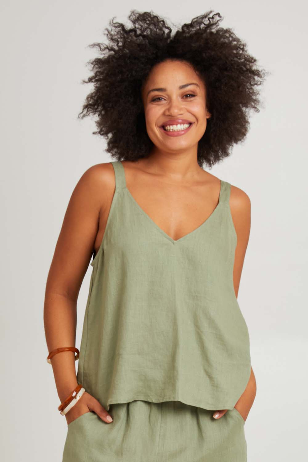 Model Olivia wearing size S of the Sojourn Linen Tank in colour Aloe (Green), from the front, cropped image