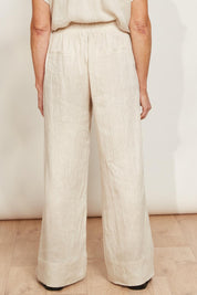 A model wearing the Studio Linen Pant in colour Tusk, from the back