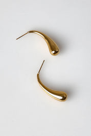 A model wearing the Halcyon Drop Earring in colour Gold (Metallics), from the front, showing the whole outfit