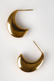 A model wearing the Halcyon Cresent Earring in colour Gold (Metallics), from the front, showing the whole outfit