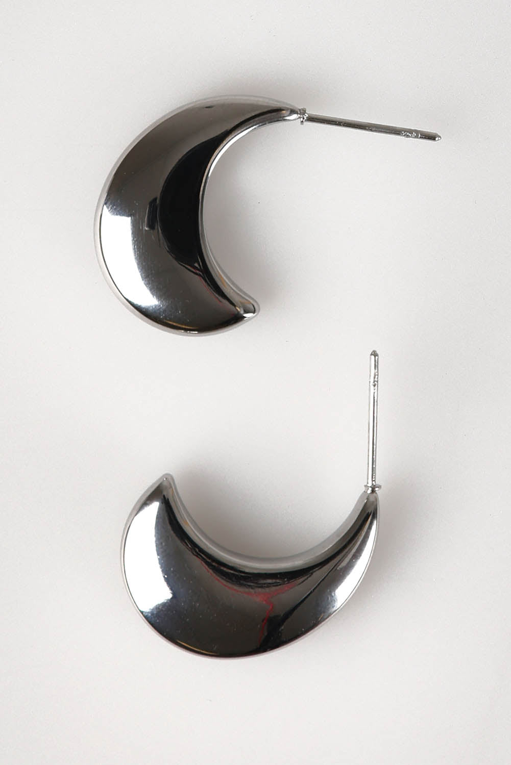 A model wearing the Halcyon Cresent Earring in colour Silver (Metallics), from the front, showing the whole outfit