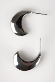 A model wearing the Halcyon Cresent Earring in colour Silver (Metallics), from the front, showing the whole outfit