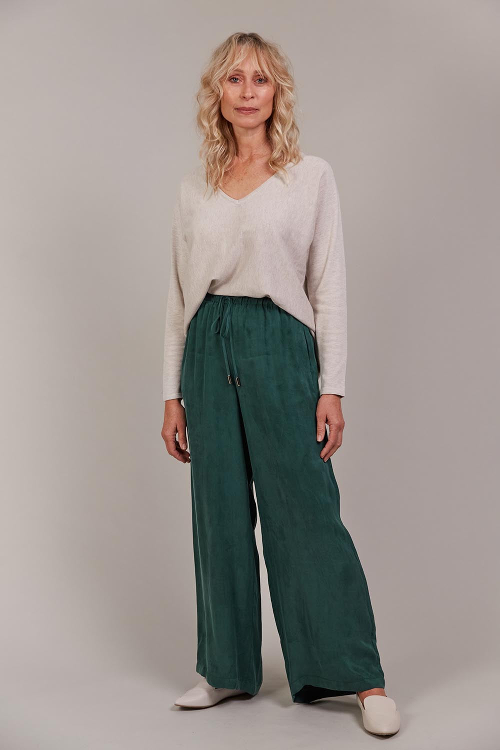 A model wearing the Eden Cupro Blend Pant in colour Aventurine (Green), from the front, showing the whole outfit