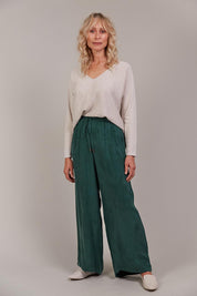 A model wearing the Eden Cupro Blend Pant in colour Aventurine (Green), from the front, showing the whole outfit