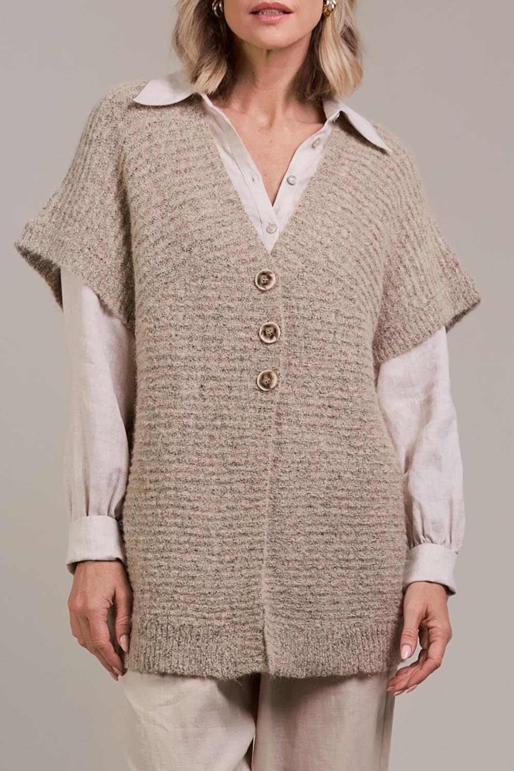 A model wearing the Folie Button Vest in colour Oat, from the front, cropped image