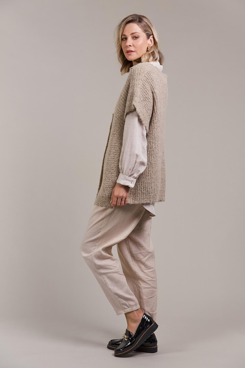 A model wearing the Folie Button Vest in colour Oat, from the front, showing the whole outfit