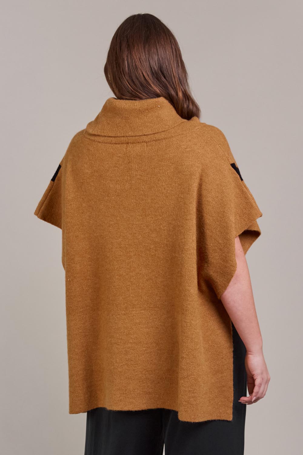 A model wearing the Avino Poncho in colour Tobacco, from the back