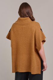 A model wearing the Avino Poncho in colour Tobacco, from the back