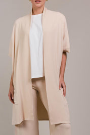 A model wearing the Palmer Vest Cardigan in colour Ecru, from the front, cropped image