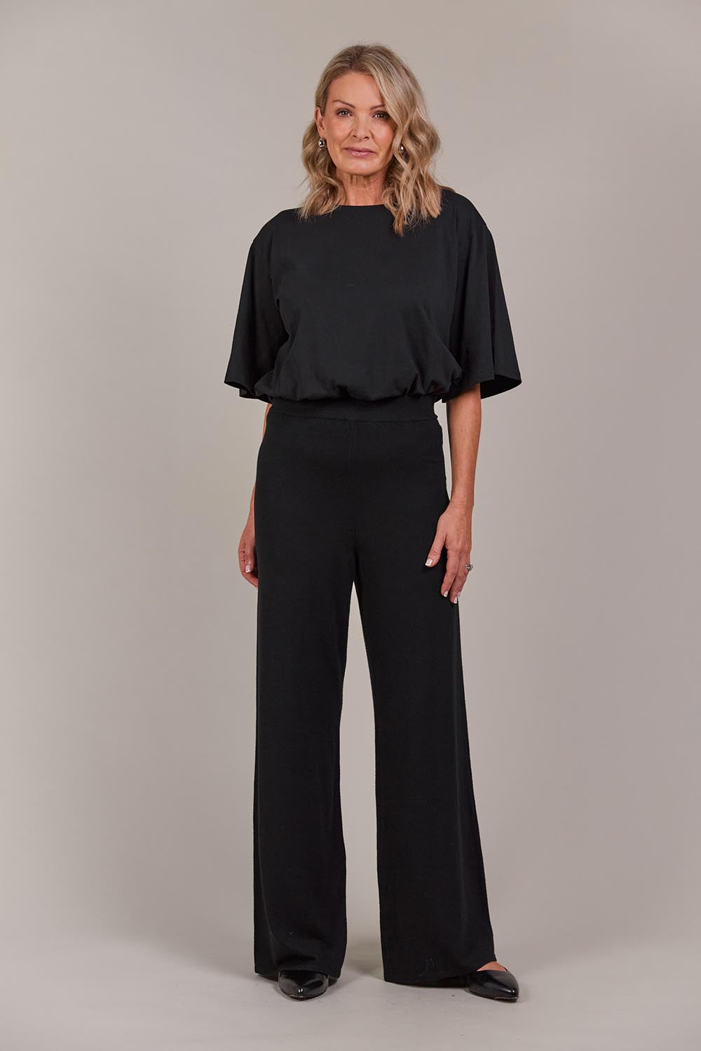 A model wearing the Palmer Knit Pant in colour Black (Black), from the front, showing the whole outfit