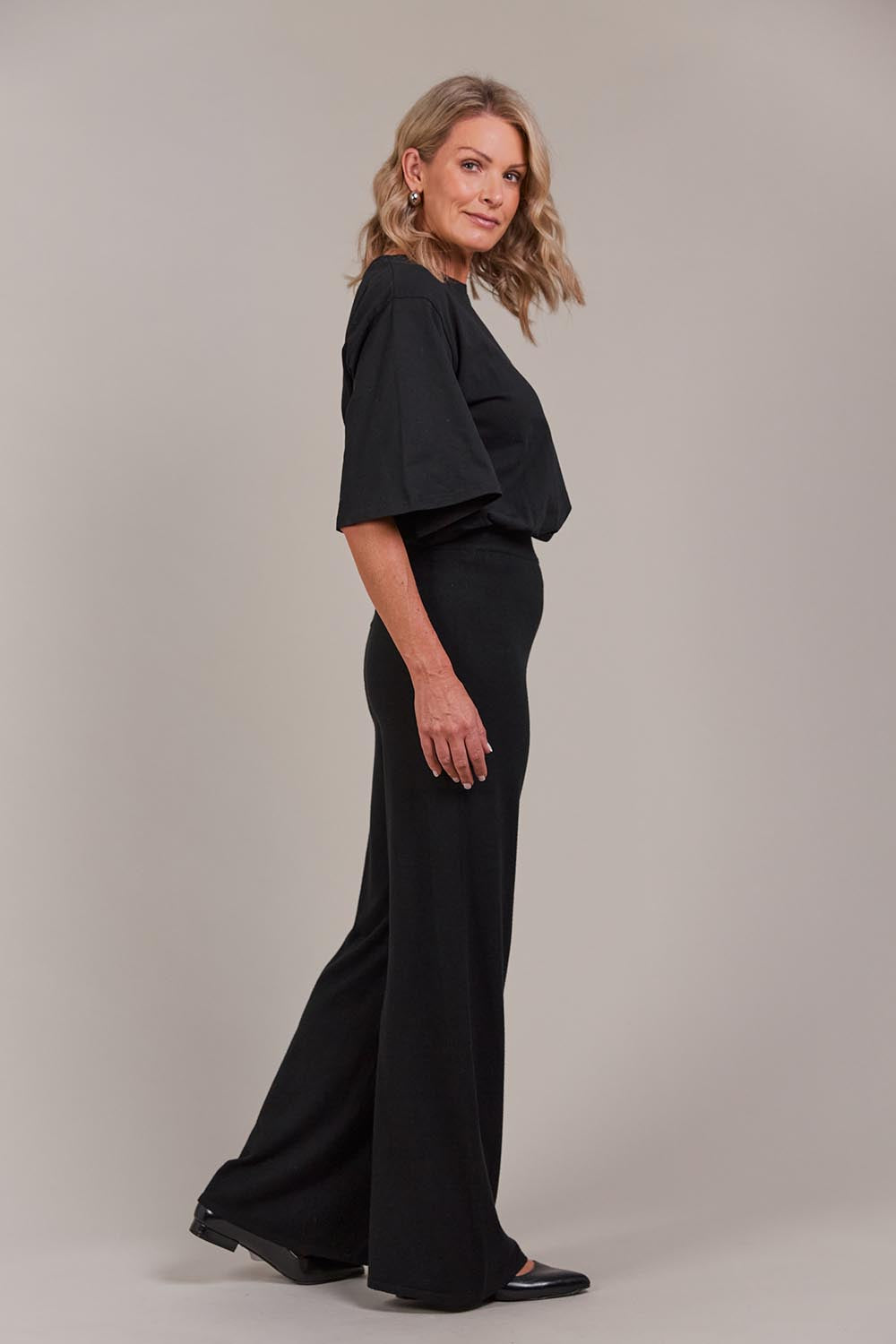 A model wearing the Palmer Knit Pant in colour Black (Black), from the front, showing the whole outfit