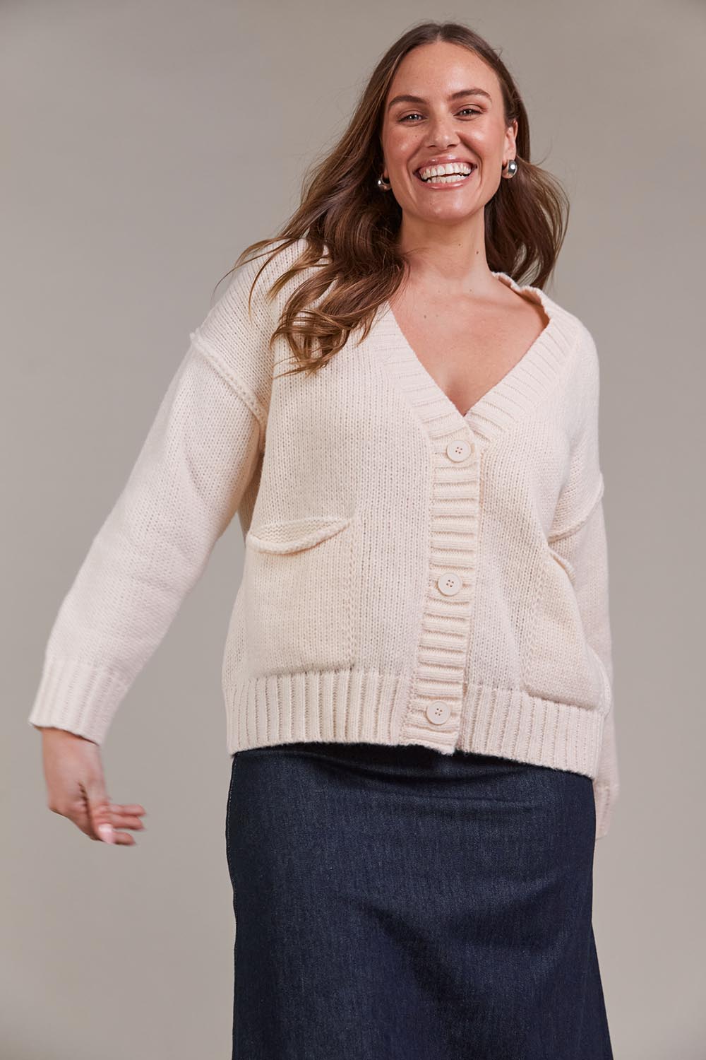 A model wearing the Katana Cardigan in colour Ecru, from the front, cropped image