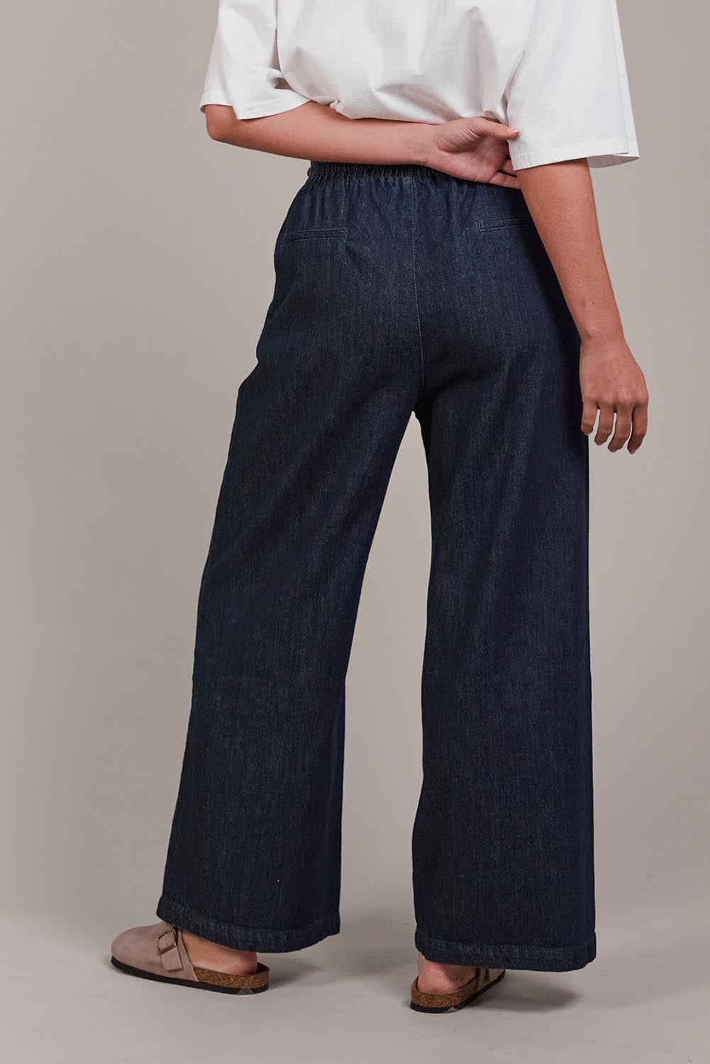 A model wearing the Pepi Wide Leg Denim Pant in colour Oxford (Blue), from the back
