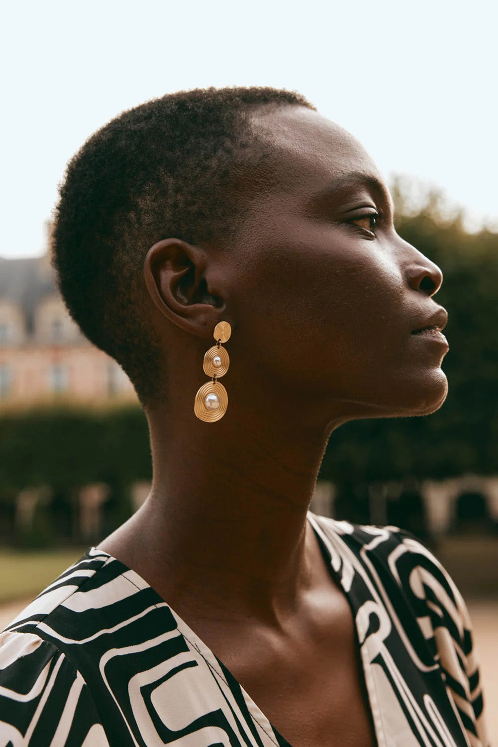 A model wearing the Laax Pearl Drop Earring in colour Gold (Metallics), from the front, showing the whole outfit