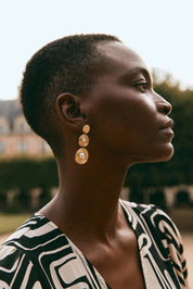 A model wearing the Laax Pearl Drop Earring in colour Gold (Metallics), from the front, showing the whole outfit