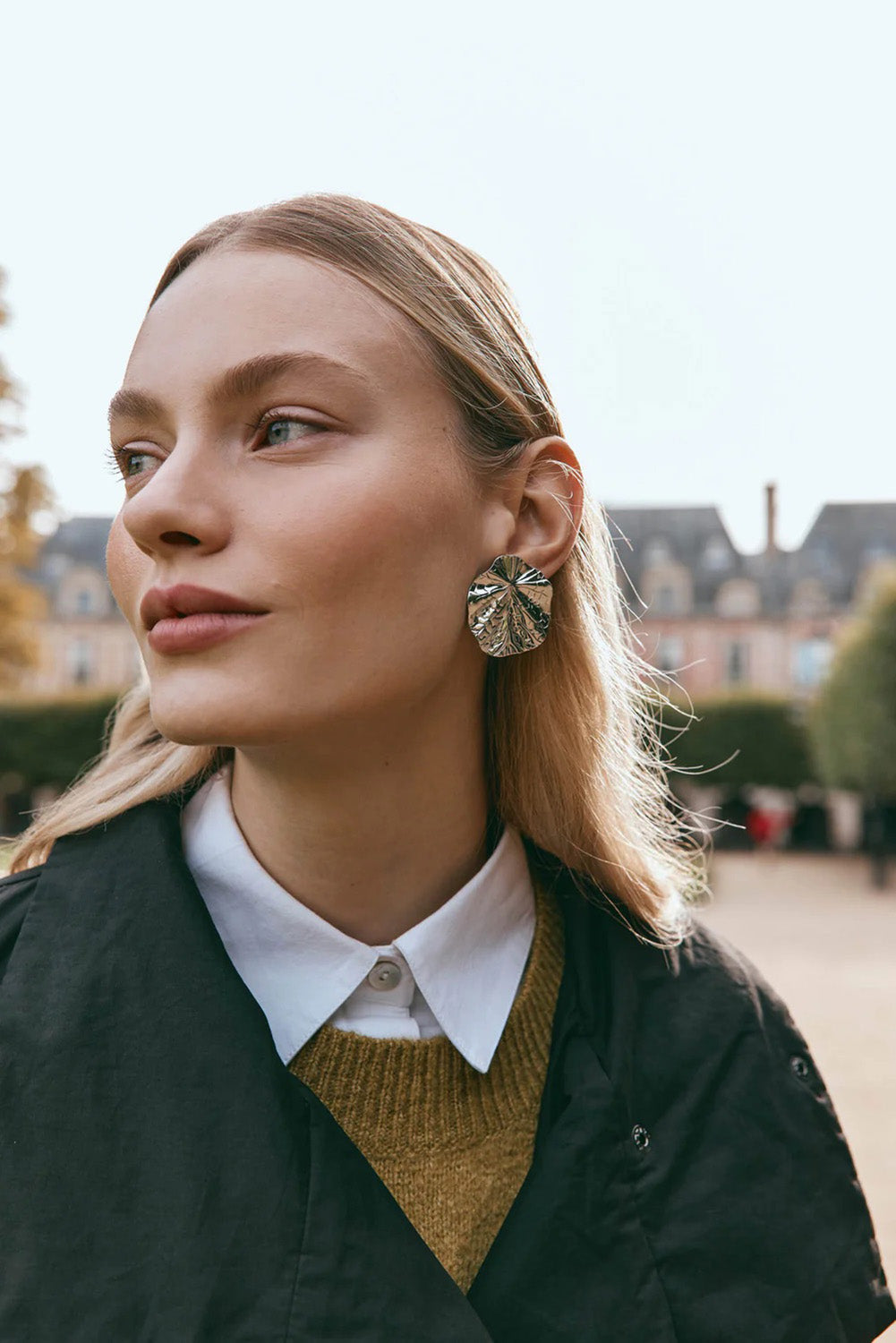 A model wearing the Aman Fan Earring in colour Silver (Metallics), from the front, showing the whole outfit