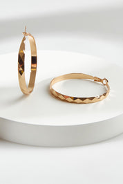 A model wearing the Estel Pressed Hoop Earring in colour Gold (Metallics), from the front, showing the whole outfit