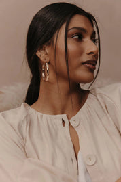 A model wearing the Estel Pressed Hoop Earring in colour Gold (Metallics), from the front, showing the whole outfit