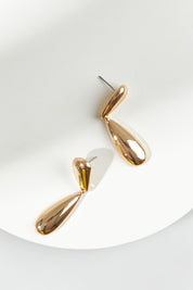 A model wearing the Pepi Drop Earring in colour Gold (Metallics), from the front, showing the whole outfit