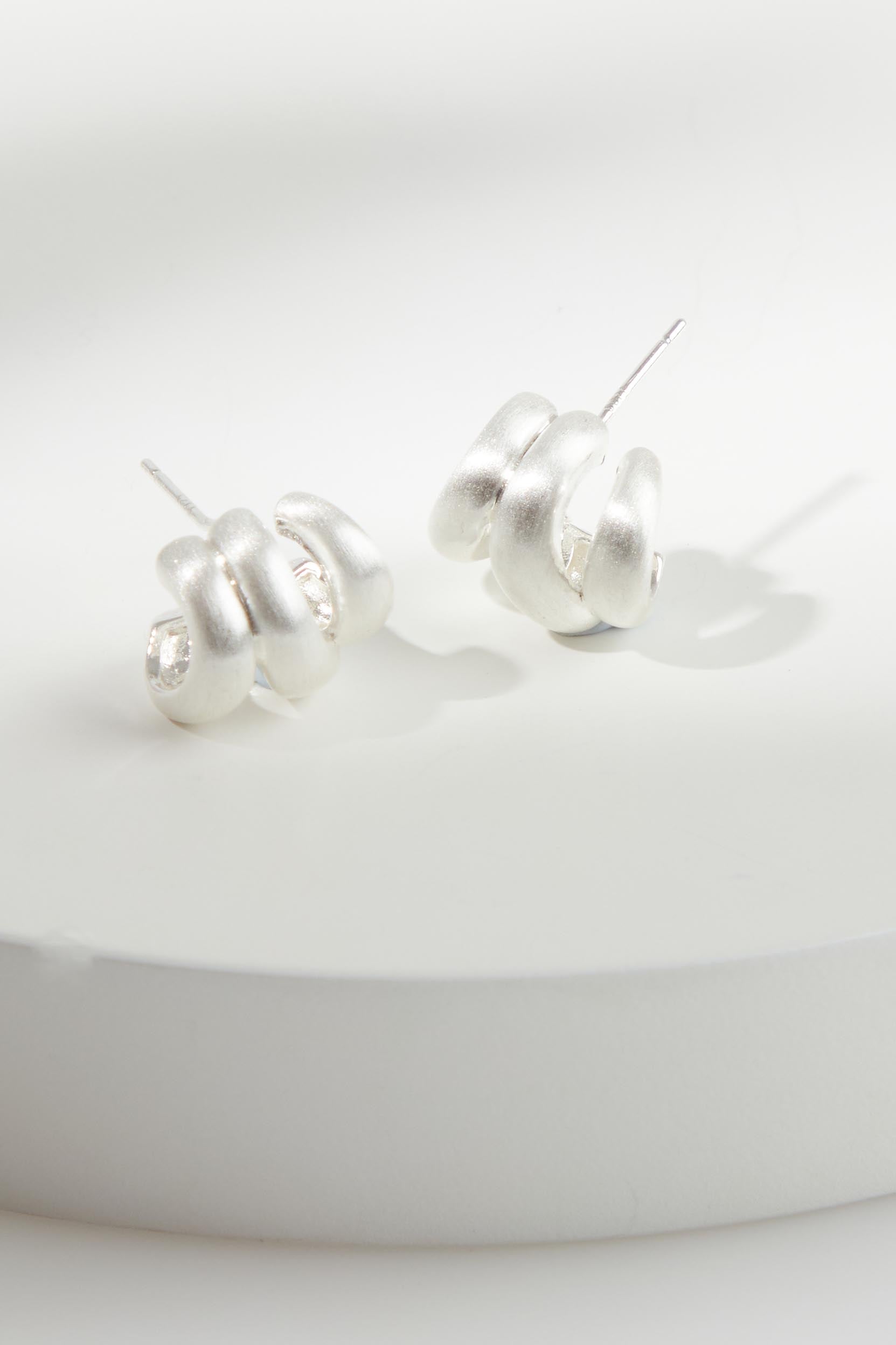A model wearing the Heritage Satin Knot Cuff Earring in colour Silver (Metallics), from the front, showing the whole outfit