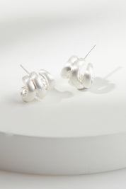 A model wearing the Heritage Satin Knot Cuff Earring in colour Silver (Metallics), from the front, showing the whole outfit