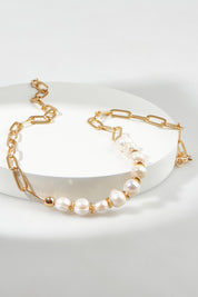 A model wearing the Ivy Pearl Necklace in colour Goldpearl (Metallics), from the front, showing the whole outfit