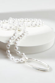 A model wearing the Laax Longline Pearl Necklace in colour Silver (Metallics), from the front, showing the whole outfit