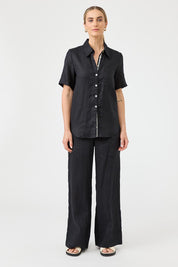 A model wearing the Studio Linen Short Sleeve Shirt in colour Black (Black), from the front, showing the whole outfit