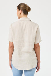 A model wearing the Studio Linen Short Sleeve Shirt in colour Dune, from the back