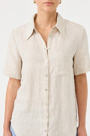 A model wearing the Studio Linen Short Sleeve Shirt in colour Dune, from the front, cropped image